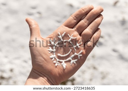 Closeup of a person using the correct amount of sunscreen in winter. 