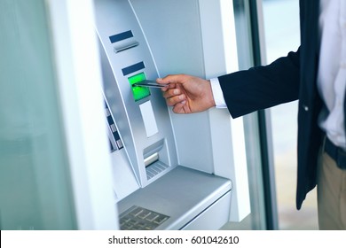 Close-up Of Person Using Credit Card To Withdrawing Money From Atm Machine