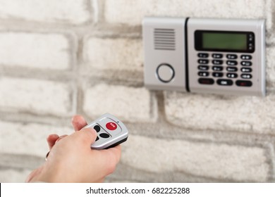 Close-up Of A Person Using Remote For Operating Door Security System