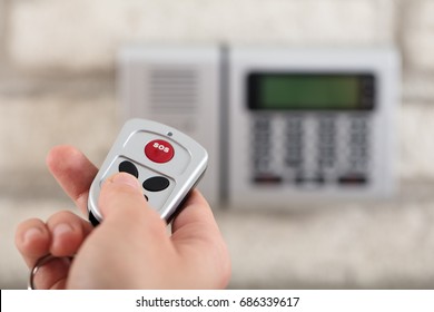 Close-up Of A Person Using Remote For Operating Door Security System