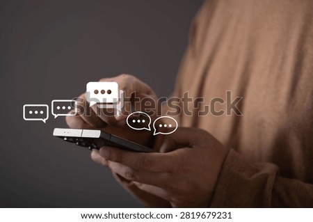 Close-up of a person using a smartphone with virtual chat icons. Concept of online communication, instant messaging, customer support, social networking, digital interaction, and mobile technology.