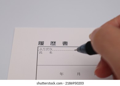 Close-up Of A Person Writing A Japanese Resume.
Translation:Curriculum Vitae, Furigana, Name, Year.