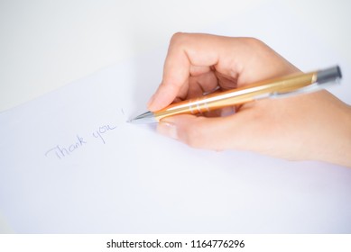 Closeup Of Person Writing Thank You Note On Sheet Of Paper. Paper Sheet Lying On Desk. Appreciation And Feedback Concept. Cropped View.