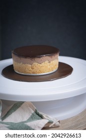 Closeup Personalised Small Chocolate Cheesecake On Cakeboard On Lazy Susan Dark Mood