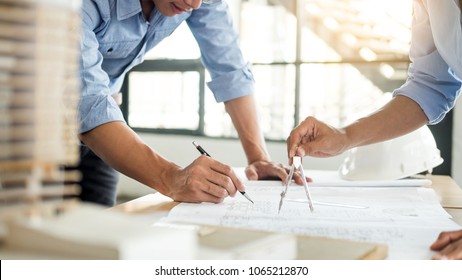 Close-up Of Person's engineer Hand Drawing Plan On Blue Print with architect equipment, Architects discussing at the table, team work and work flow construction concept. - Shutterstock ID 1065212870