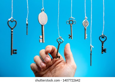 Close-up Of Person's Hand Choosing A Hanging Key Amongst Other Ones