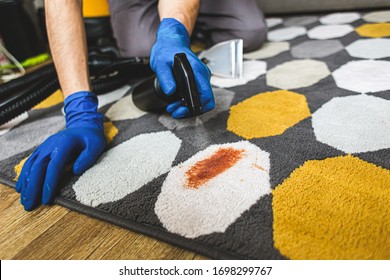 Close-up Of Person's Hand Cleaning Stain On Carpet With Sponge.