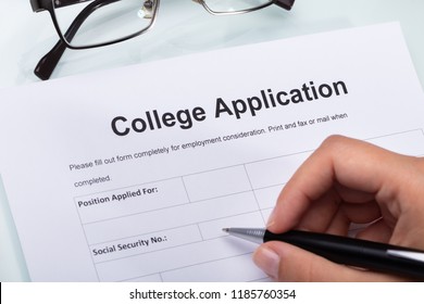 Close-up Of A Person's Hand Filling College Application Form With Pen