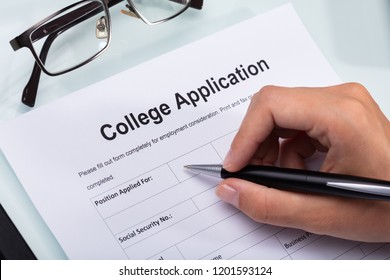 Close-up Of A Person's Hand Filling College Application Form With Pen