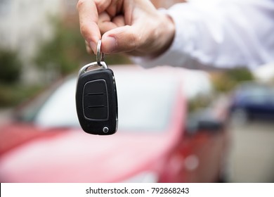 Close-up Of A Person's Hand Holding Car Key Outdoors