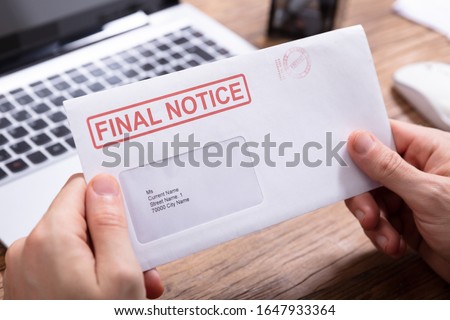 Close-up Of Person's Hand Holding Final Notice Envelope