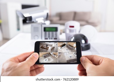 Close-up Of A Person's Hand Holding Mobile Phone With CCTV Camera Footage On Screen - Shutterstock ID 762120889