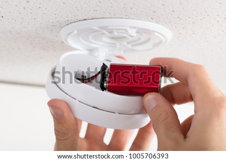 Close-up Of A Person's Hand Inserting Battery In Smoke Detector Stock photo © 