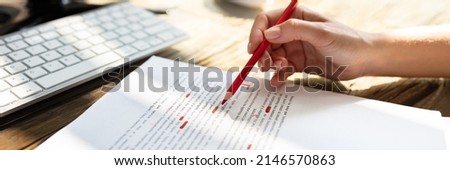 Close-up Of A Person's Hand Marking Error With Red Marker On Document