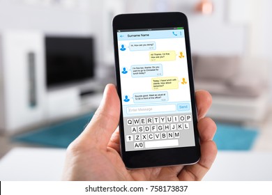 Close-up Of Person's Hand With Mobile Phone Showing Text Messages