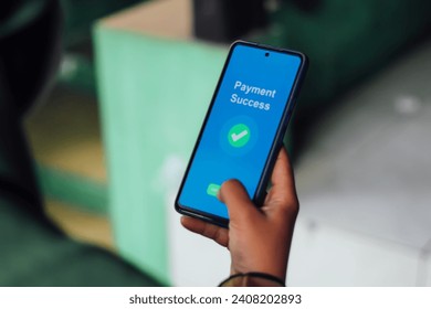 Close-up of Person's Hand Showing Payment Success Message on Smartphone Screen