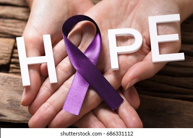 Close-up Of A Person's Hand Showing Ribbon With Hope Text To Support Alzheimers Disease Awareness