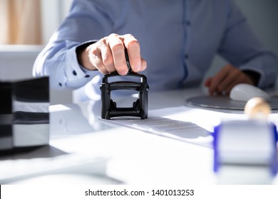 Close-up Of A Person's Hand Stamping With Approved Stamp On Document At Desk - Shutterstock ID 1401013253
