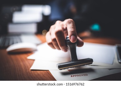 Close-up Of A Person's Hand Stamping With Approved Stamp On Text Approved Document At Desk,  Contract Form Paper