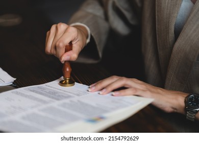 Close-up of a person's hand stamping with approved stamp on certificate document public paper at desk, notary or business people work from home, isolated for coronavirus COVID-19 protection - Shutterstock ID 2154792629
