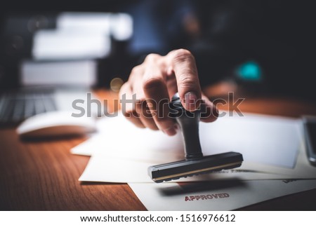 Close-up Of A Person's Hand Stamping With Approved Stamp On Text Approved Document At Desk,  Contract Form Paper