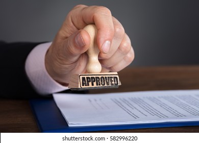 Close-up Of A Person's Hand Stamping On Approved Document