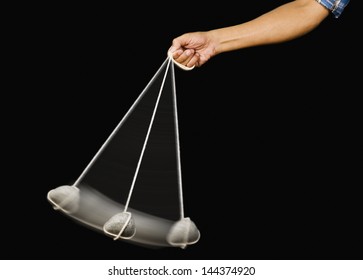 Close-up Of A Person's Hand Swinging A Stone Pendulum