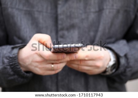 Close-up of persons hand using device for communication. Mobile phone for fun and entertainment. Man using modern gadget. Technology and addiction concept