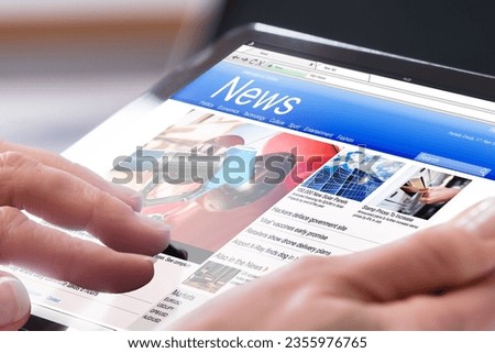 Close-up Of A Person's Hand Using Digital Tablet With Screen Showing Online News