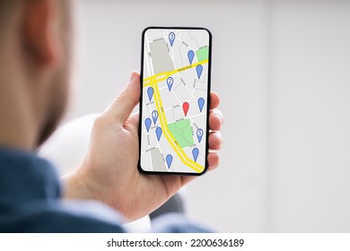 Close-up Of A Person's Hand Using GPS Navigation Map On Mobile Phone
