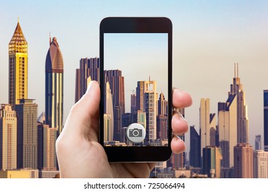 Close-up Of Person's Hand Using Mobile Phone To Capture City Buildings