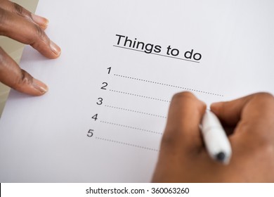 Close-up Of Person's Hand Writing Things To Do List On Paper