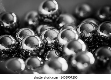 Close-up and perspective with the blurring of many objects forming an ordered structure. Metal shiny balls to shoot from a sling, evenly arranged.