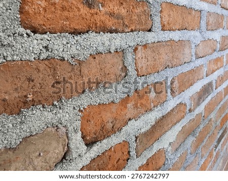 Close-up perspective of a red brick wall with thick, rough mortar joints.
