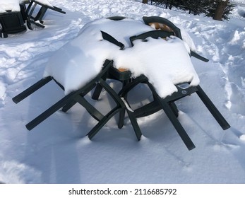 A Close-up Perspective Shoot Of A Table And Garden Chairs Under The Snow, In Winter. Objects Under Snow. Welcoming Winter With Snow. Snow Load. No People. Outdoor Furniture After Snowfall. Cold.