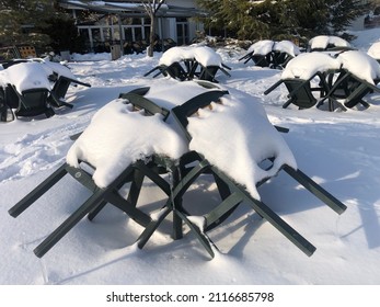 A Close-up Perspective Shoot Of A Table And Garden Chairs Under The Snow, In Winter. Objects Under Snow. Welcoming Winter With Snow. Snow Load. No People. Outdoor Furniture After Snowfall. Cold.