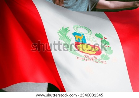 Close-up of the Peruvian flag waving, showcasing its vibrant red and white colors and intricate coat of arms. The flag of Peru is a symbol of national pride. Flag of Peru.