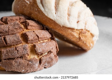 Closeup photo of 2 typical Mexican sweet bread called Conchas over a white plate. Chocolate and vanilla flavors.