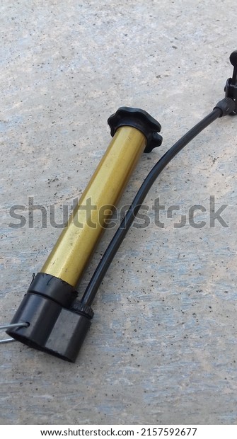 close-up photo of the air pump on a cement tile\
background. hand bike\
pump