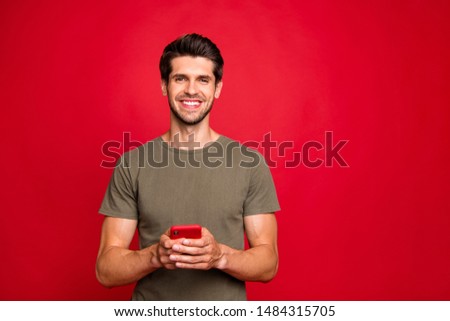 Closeup photo of amazing guy holding modern telephone hands casual outfit isolated on bright red background