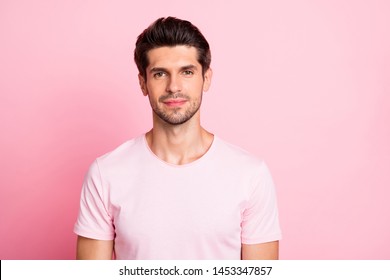 Fotografía de cierre de un asombroso macho sin sonreír, vestido casual aislado de fondo rosa