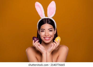 Closeup photo of asian ethnicity pretty girl wear easter fluffy ears hold eggs prepare dinner isolated background