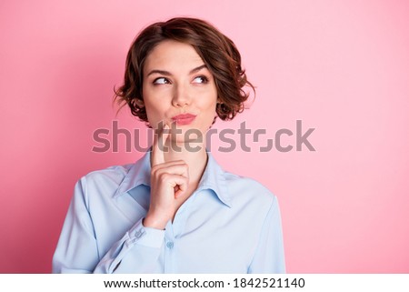 Closeup photo of attractive charming lady arm finger on chin look tricky side up empty space cunning smart intelligent person wear blue office shirt isolated pink pastel color background