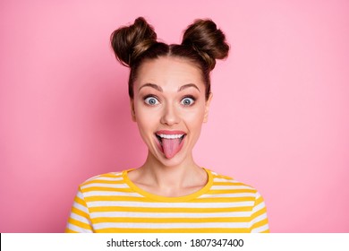 Closeup photo of attractive lady two funny buns flirty sticking tongue out mouth silly childish girlish person wear casual yellow striped shirt isolated pink color background