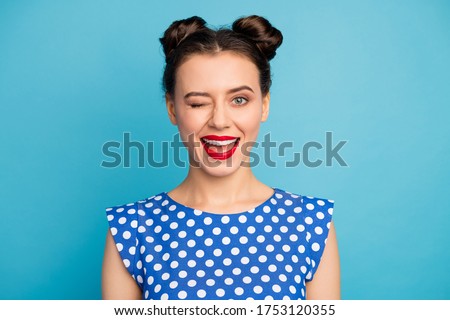 Closeup photo of attractive pretty lady red lips flirty playful mood blinking one eye see handsome guy street party wear dotted white blouse shirt isolated blue color background