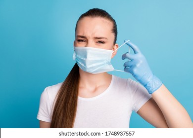 Closeup photo of beautiful but displeased lady bad mood hate always use facial respirators sensitive skin wear latex gloves protect face mask white t-shirt isolated blue color background