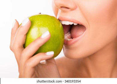 Closeup photo of a beautiful healthy girl biting an apple