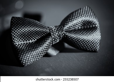 Close-up photo of black bow tie on dark background