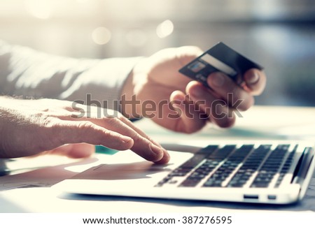 Closeup photo businessman working with generic design notebook. Online payments, hands keyboard. Blurred background, film effect. Horizontal