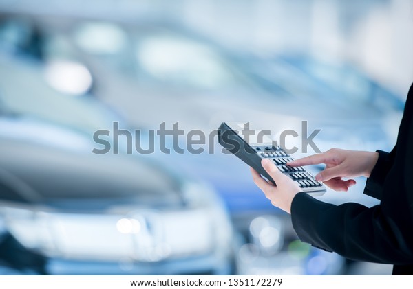 close-up photo of calculator car salesman\
Pressing a calculator to calculate the price of a new car in the\
dealer showroom and calculate the car\
interest.